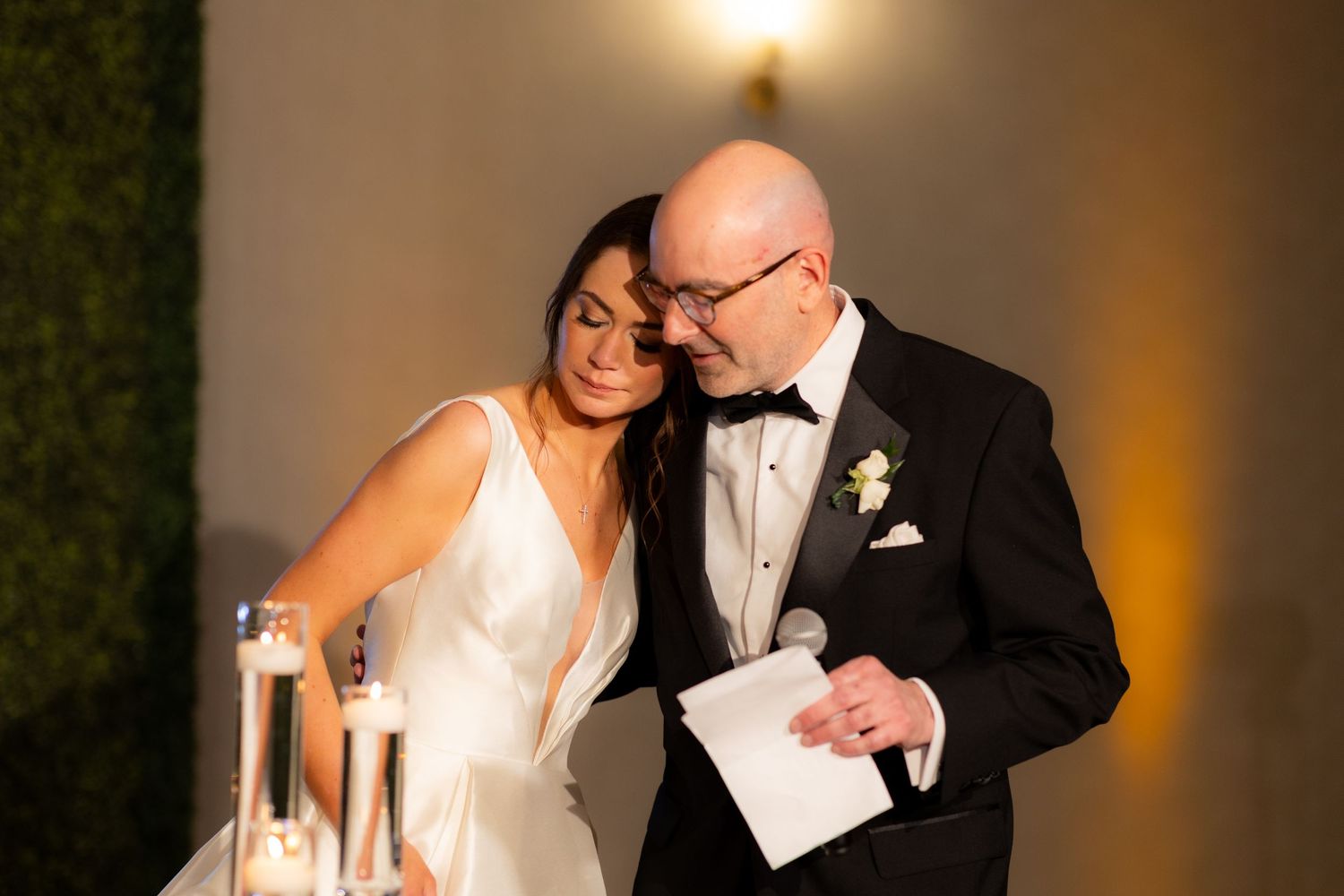 A wedding couple shares intimate moments during their reception with candlelit ambiance.