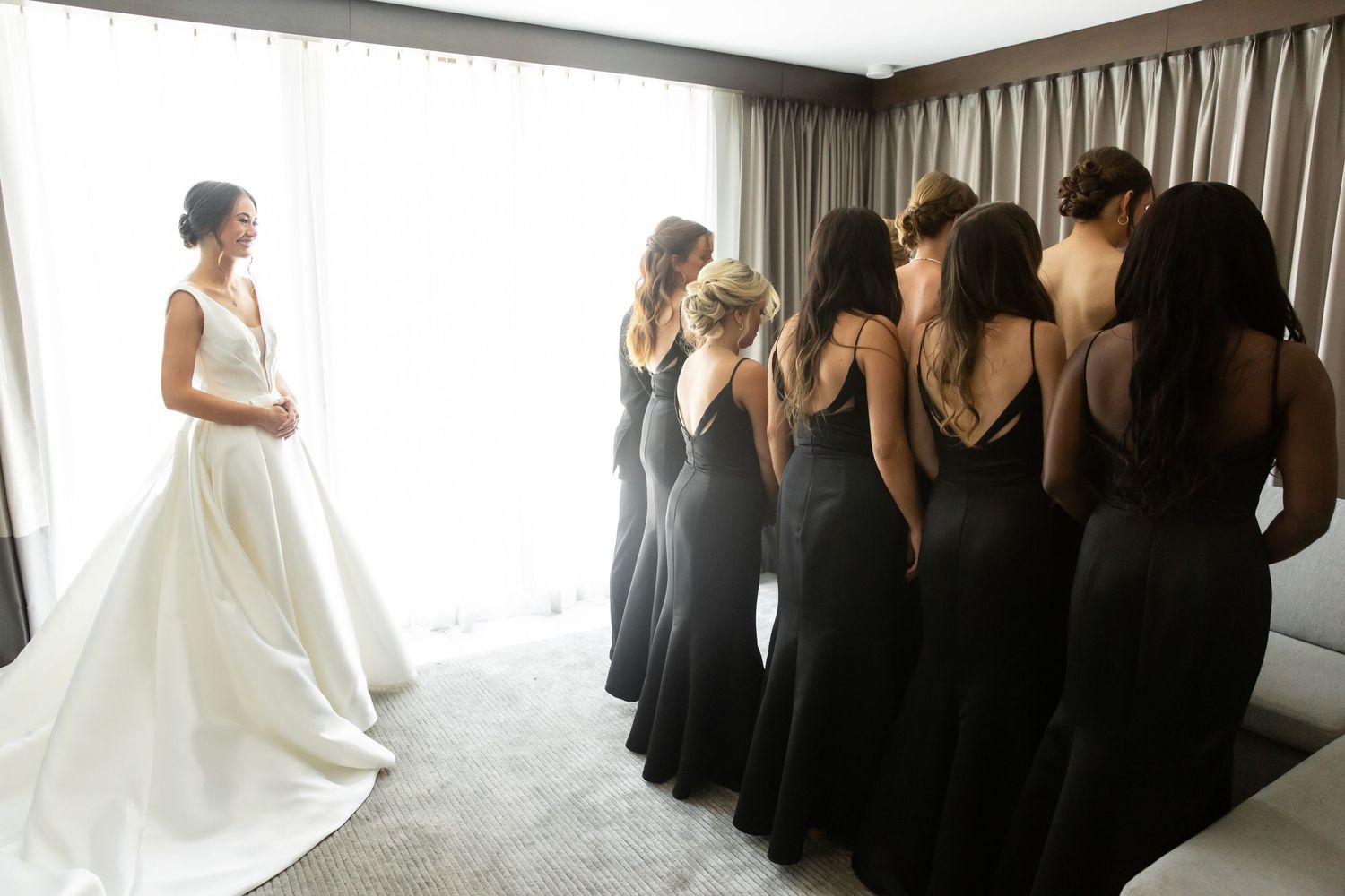 Panoramic view of wedding party with bridesmaids in black and bride in white.