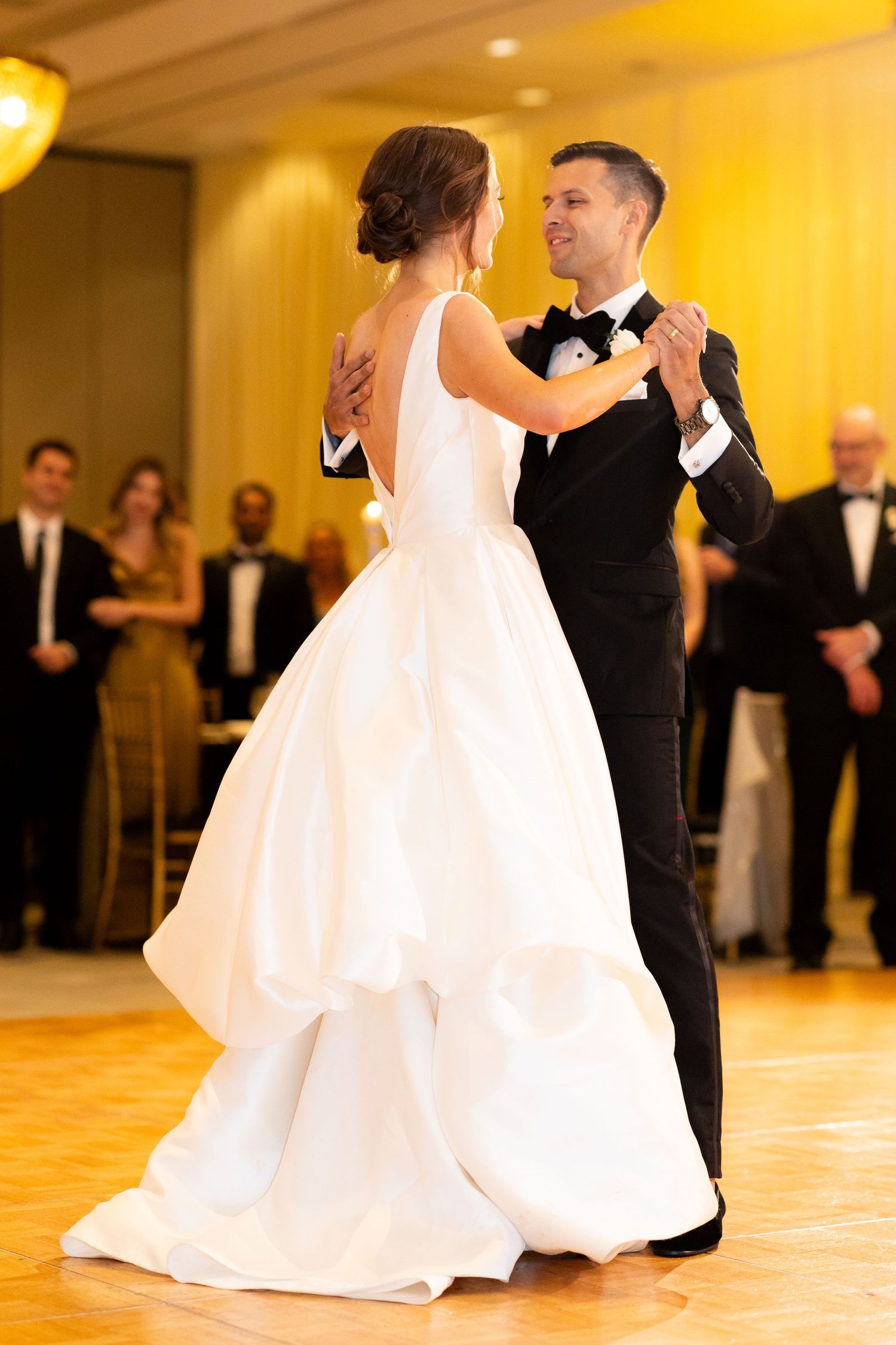 A ballroom wedding dance captured with elegant lighting and formal attire.