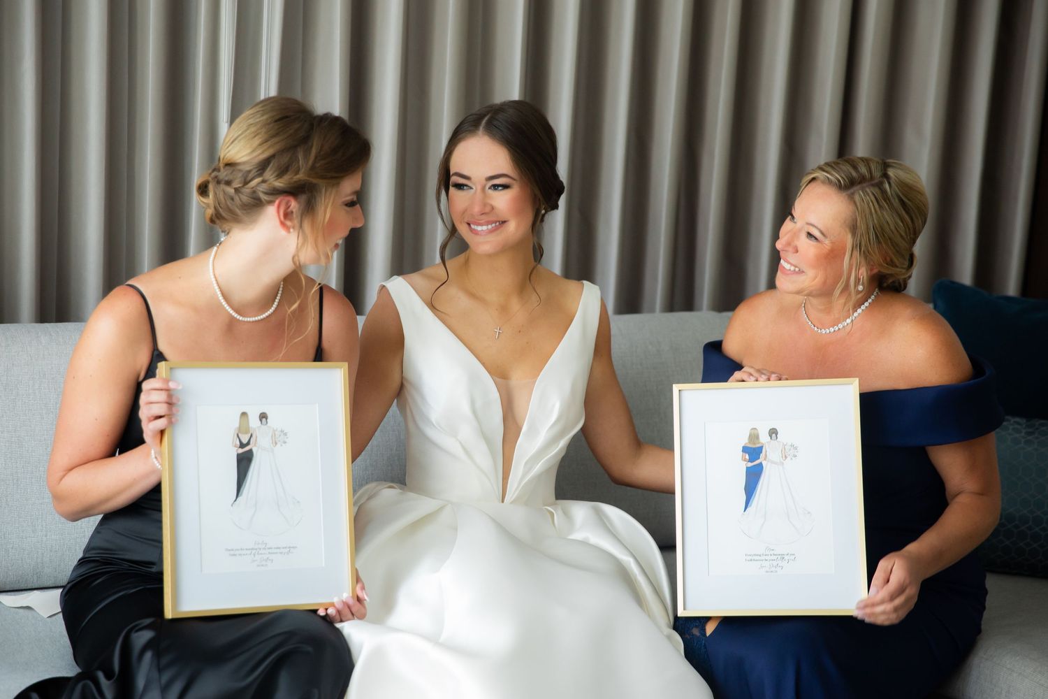 Bridesmaids smiling while looking at photos together during wedding preparations.