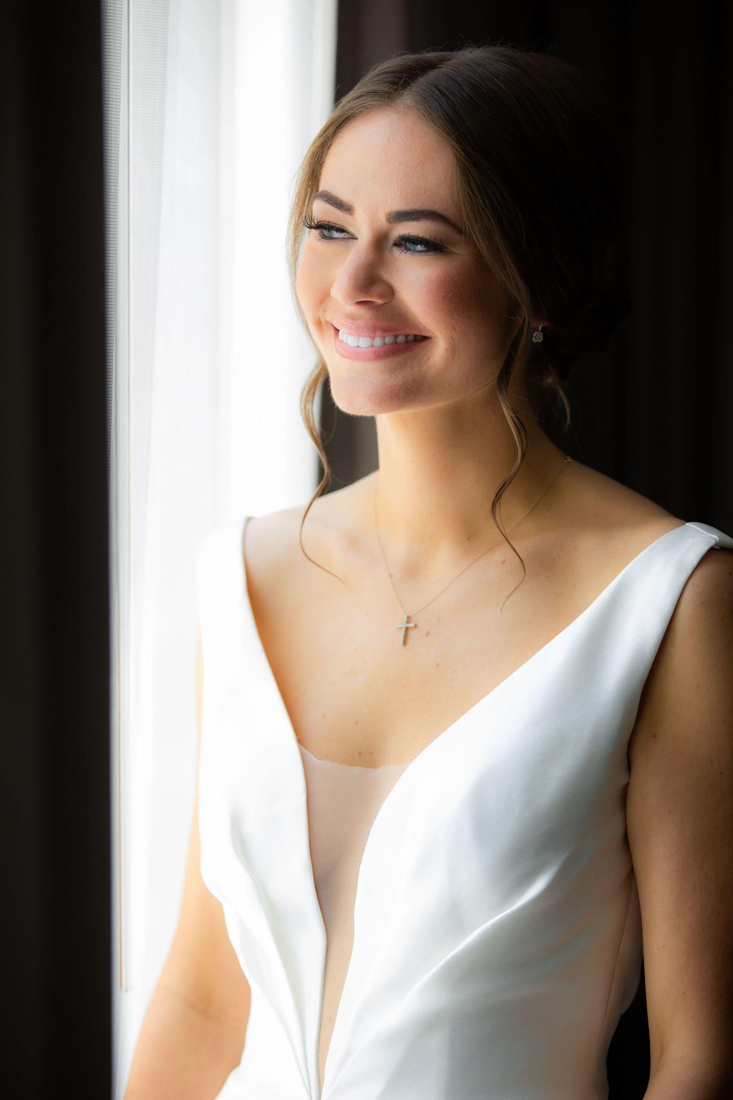 Elegant bridal portrait showcasing modern V-neck wedding gown in dramatic lighting.