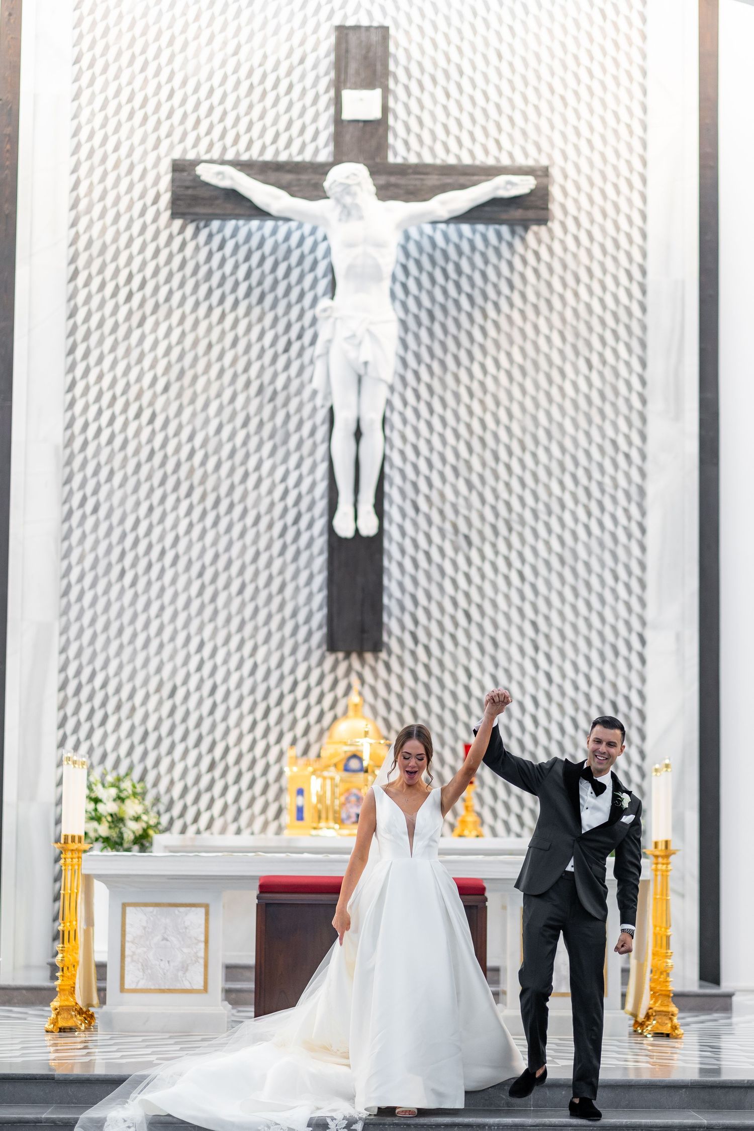 A wedding couple celebrates their ceremony in a modern church with distinctive architectural features.