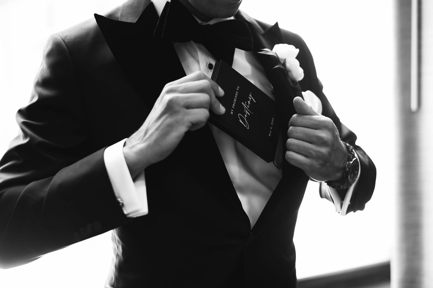 Silhouetted figures in formal wear prepare for an event near large windows.