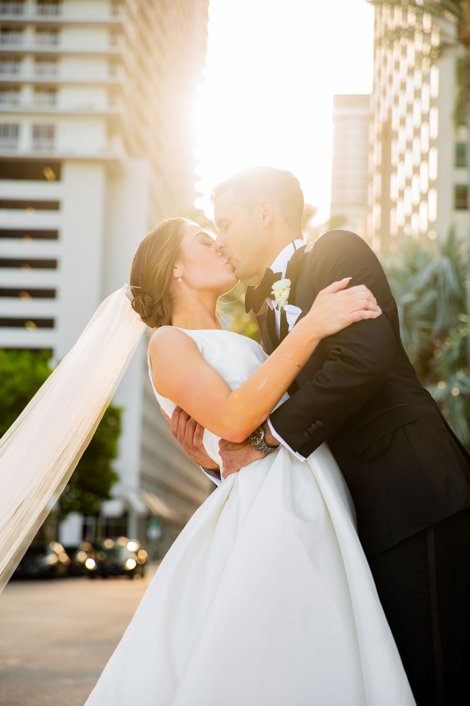 Golden sunlight illuminates romantic wedding portrait session in an urban garden setting.