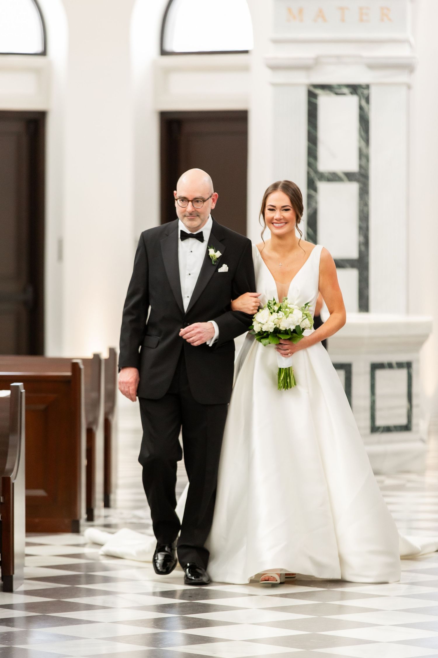 A processional walk down a church aisle with black and white checkered floor tiles.