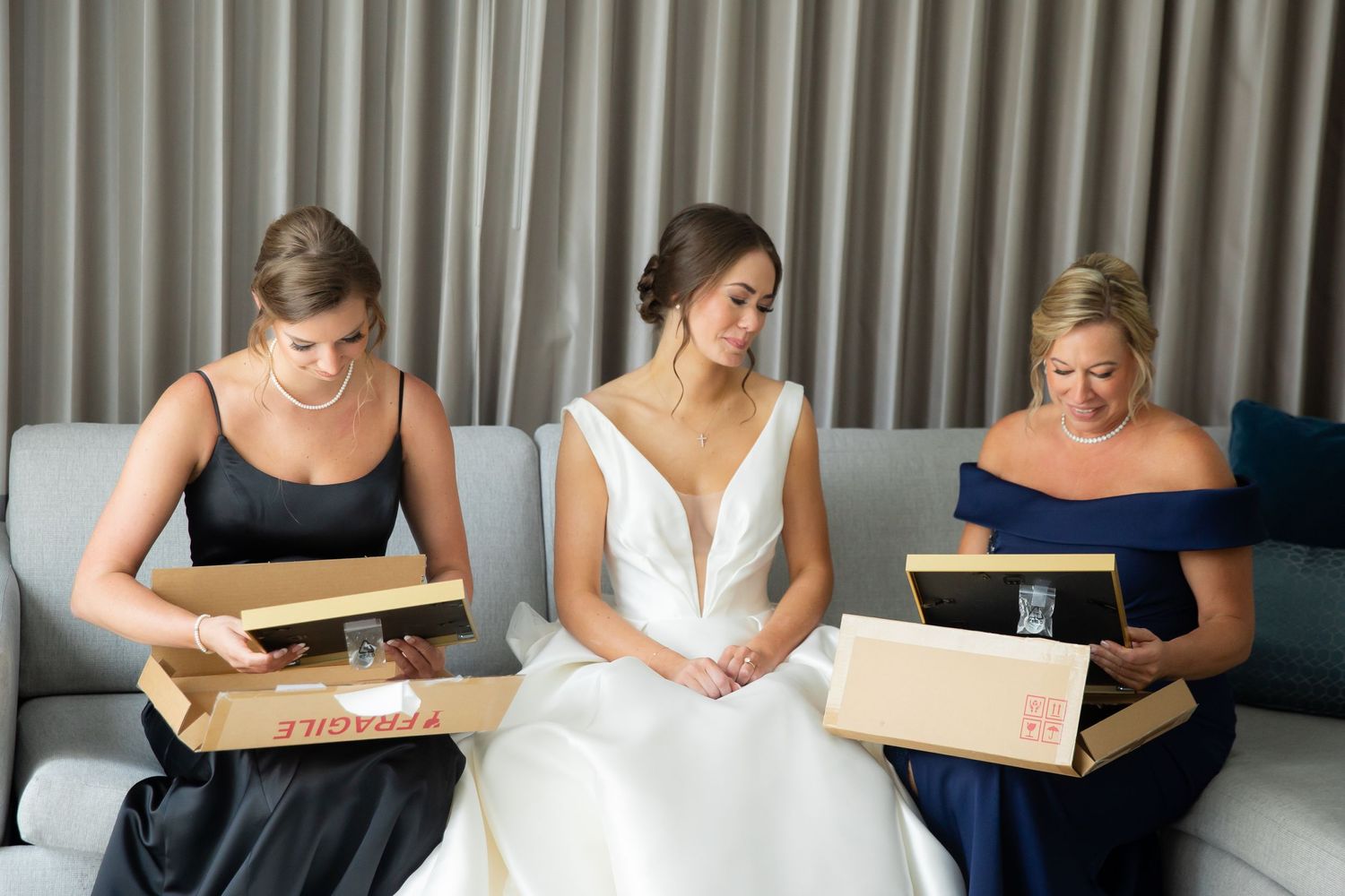 Wedding party opening gifts and sharing laughter during pre-ceremony preparations.