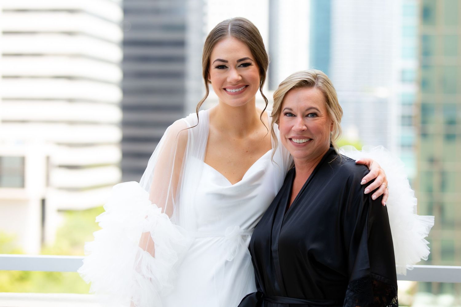 Candid moments shared between wedding party members on a bright urban rooftop.