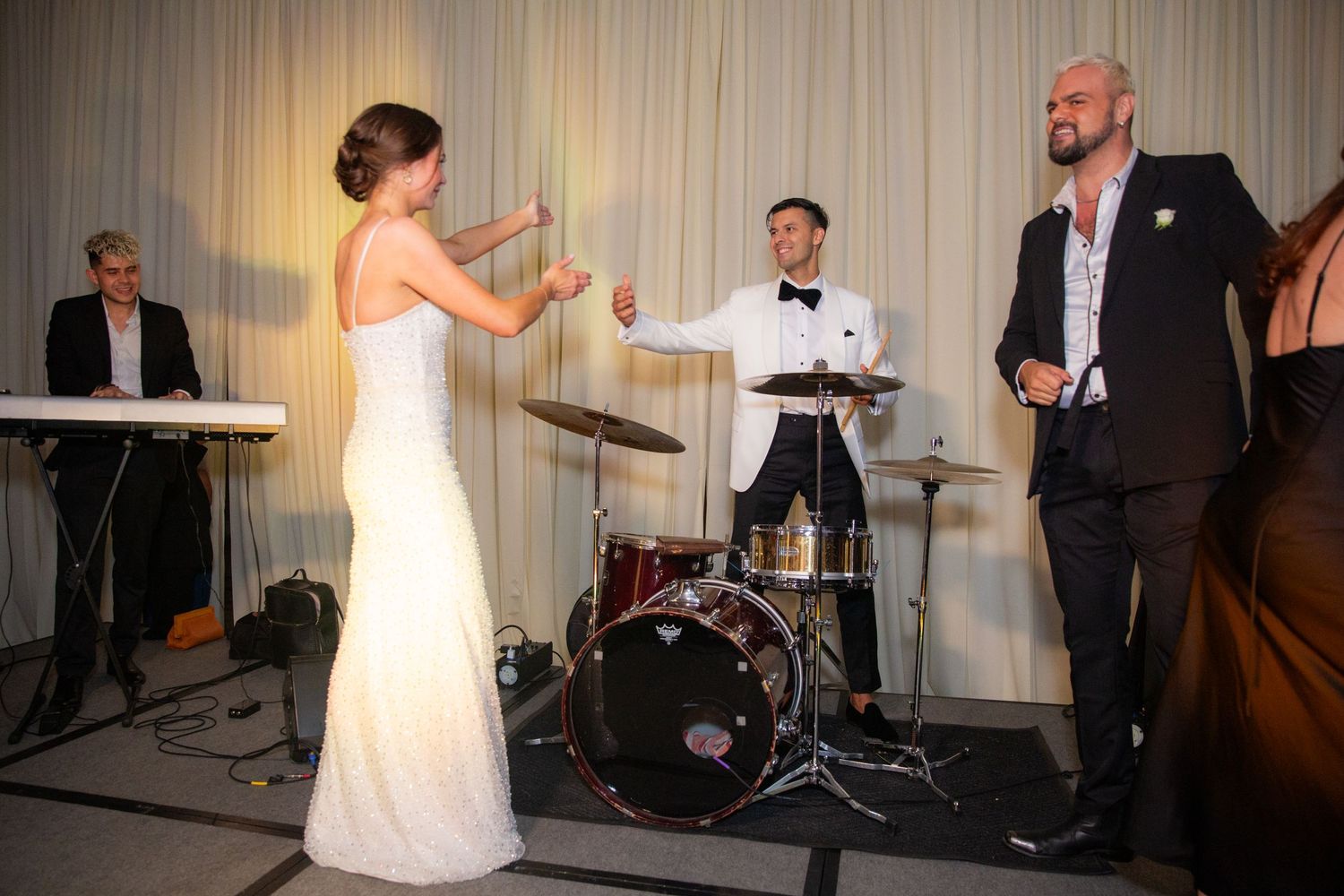 Musicians entertain guests at an elegant reception with live band setup.