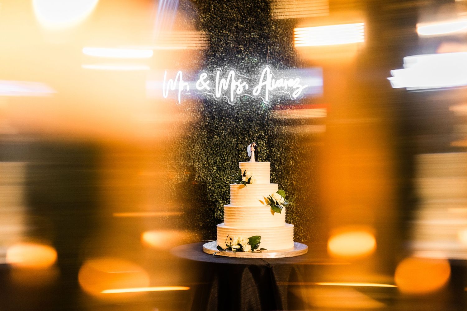 Wedding reception detail shot with warm bokeh lighting effects and soft focus decor elements.