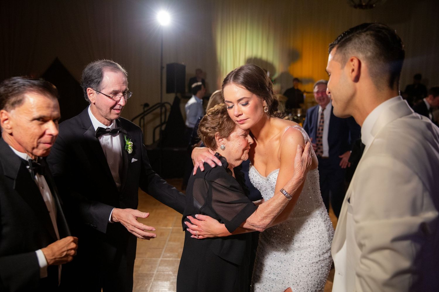 Wedding reception guests sharing intimate dances under dimmed ballroom lighting.