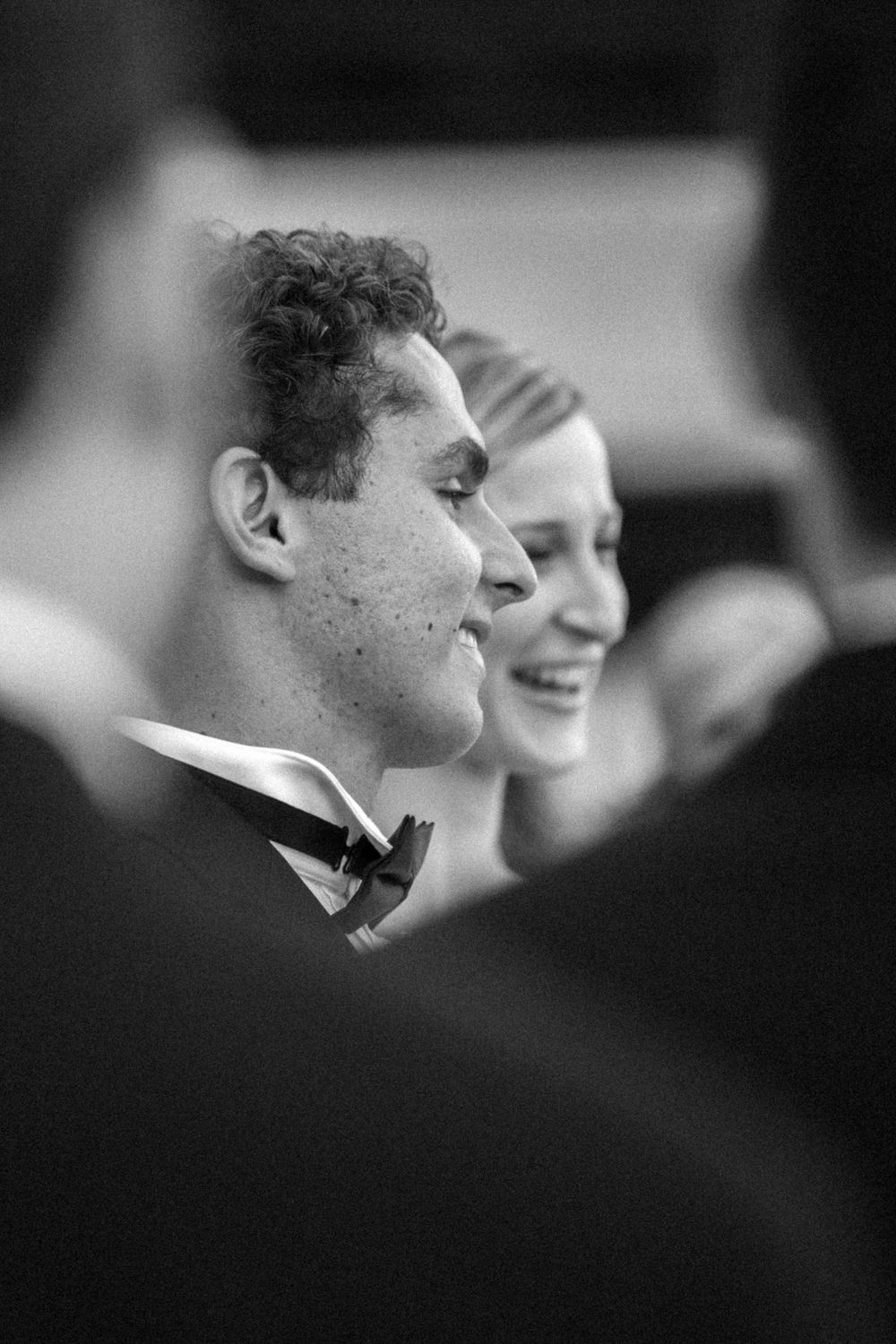 Black and white photograph of a couple smiling together at a formal event, the man wearing a bowtie.