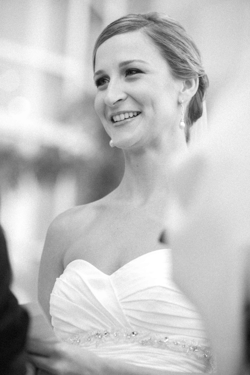 Black and white wedding portraits showing a bride in an elegant white gown with soft lighting and joyful expressions.