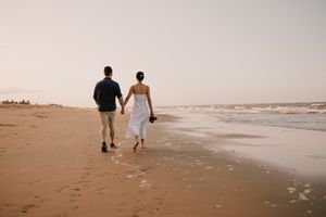 engagement couple holding hands at sunset at Saunders Beach in Townsville