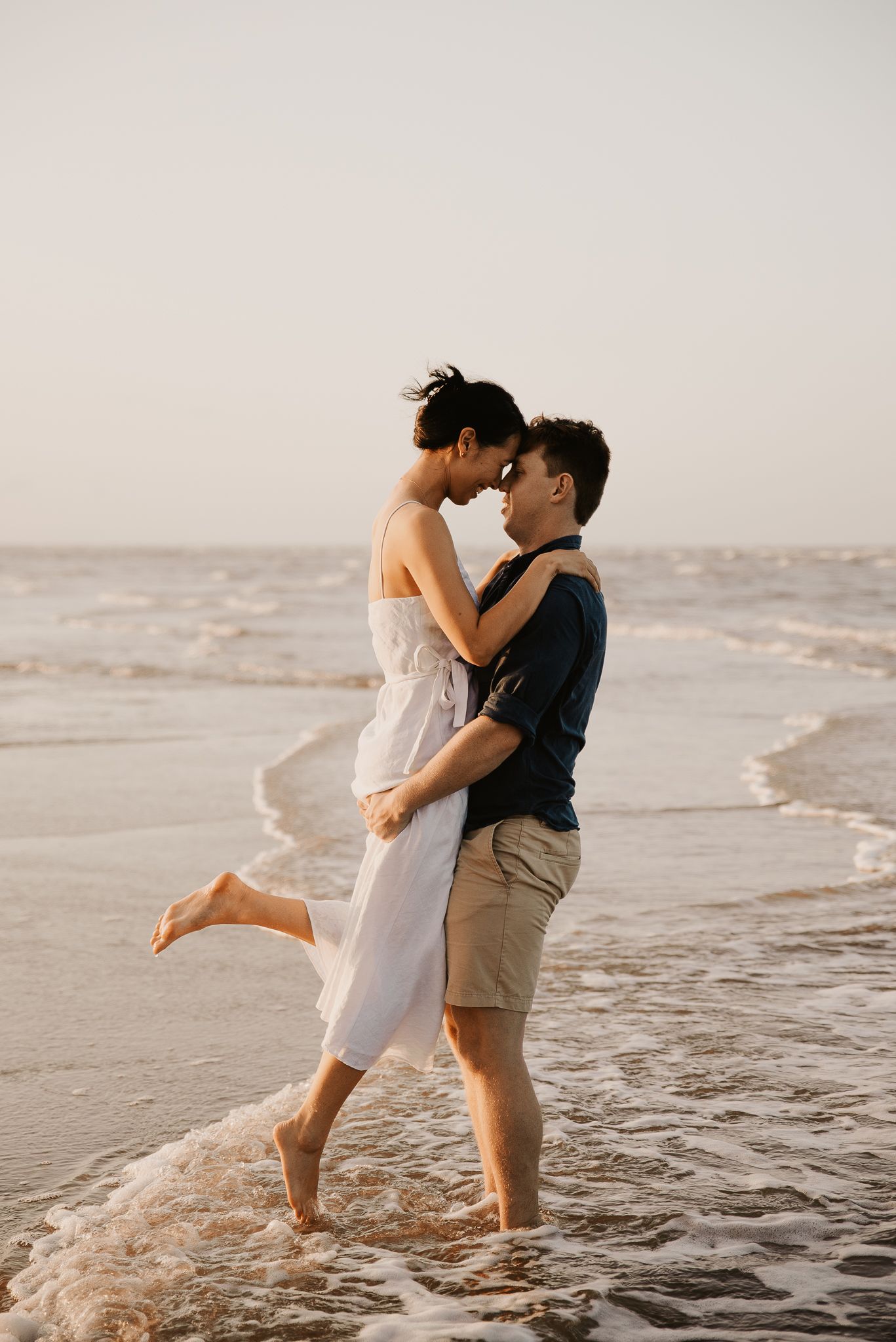 engagement couple at sunset touching foreheads at Saunders Beach in Townsville