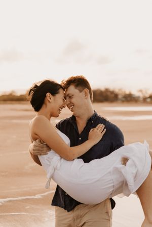 engagement couple being carried at sunset at Saunders Beach in Townsville
