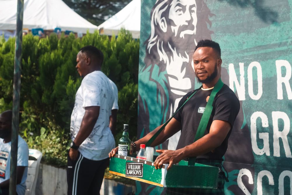 Staff members working at an outdoor venue with a large mural visible in the background.