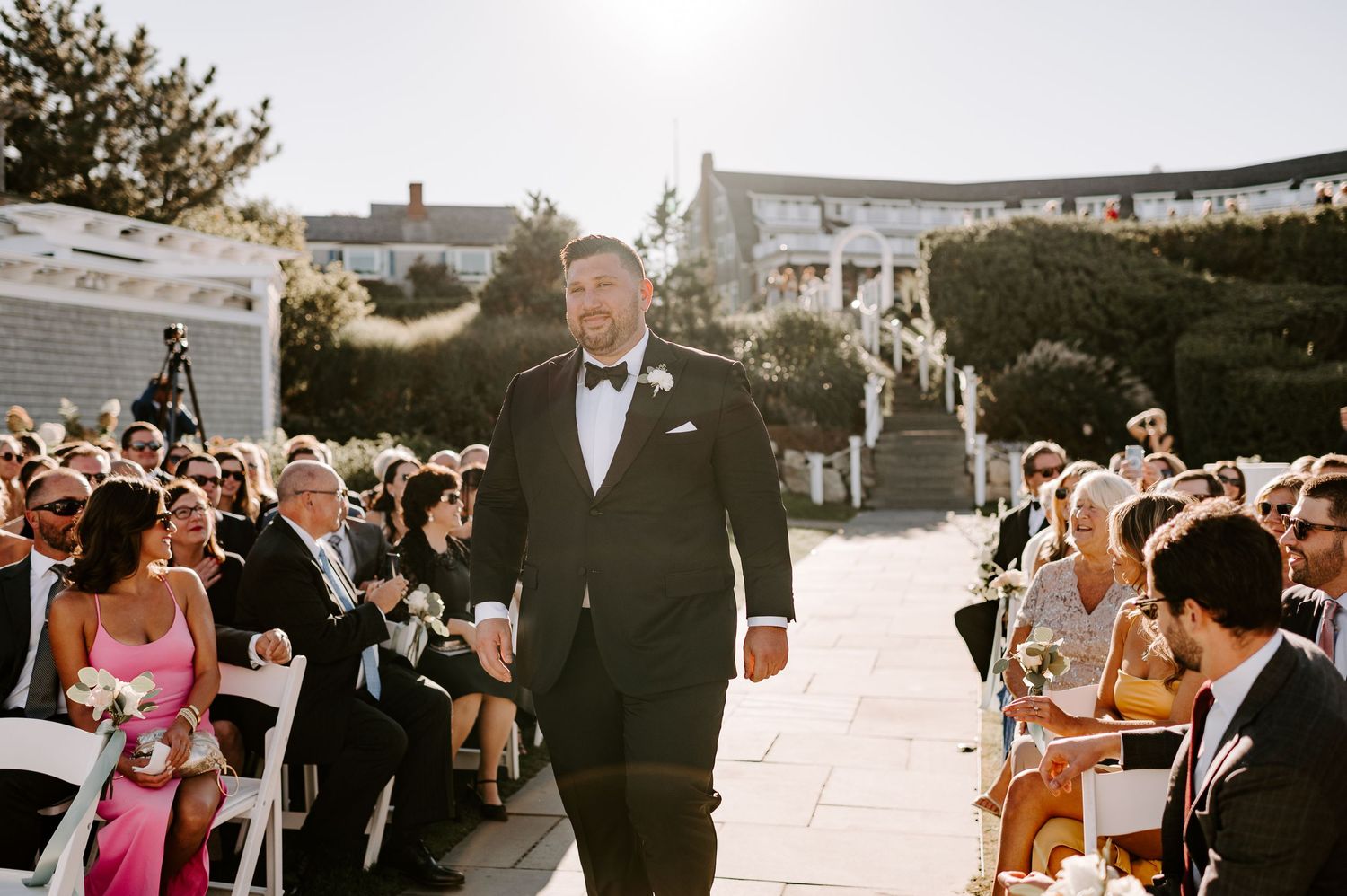 Wedding guests mingling during an outdoor reception by the beach.