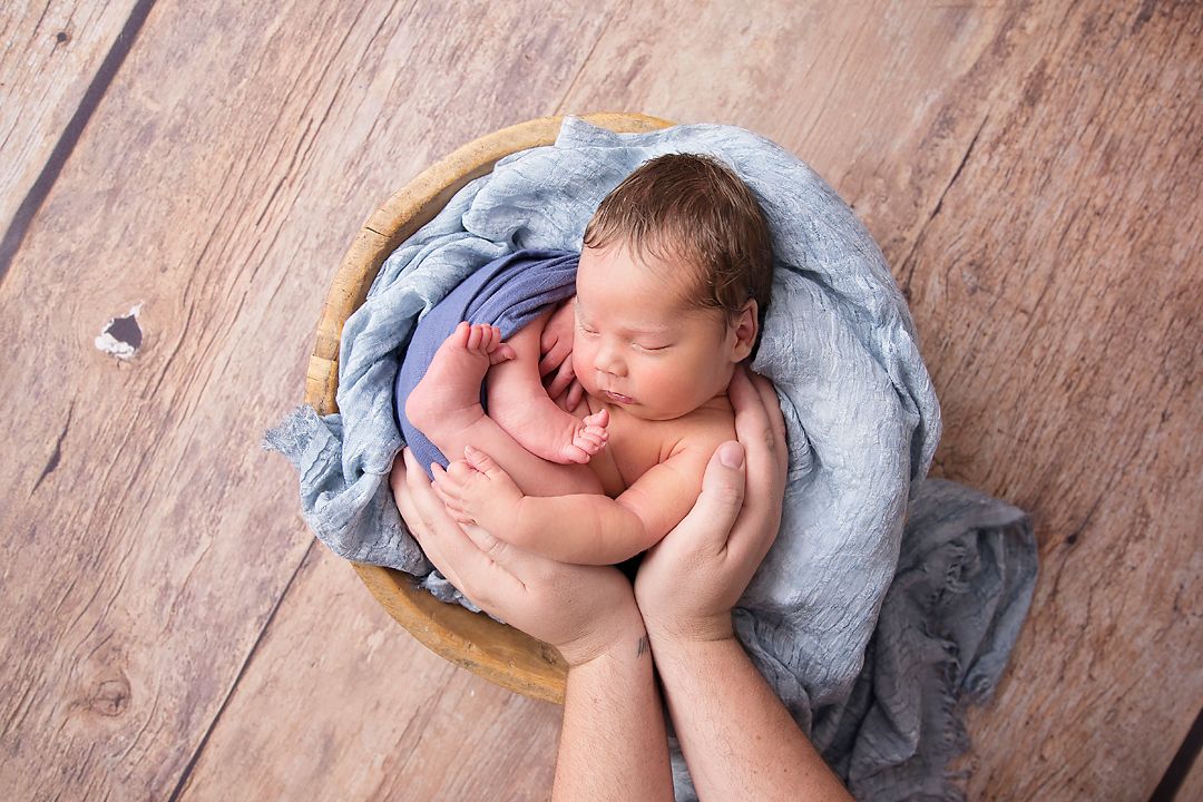 baby boy with dad's hands