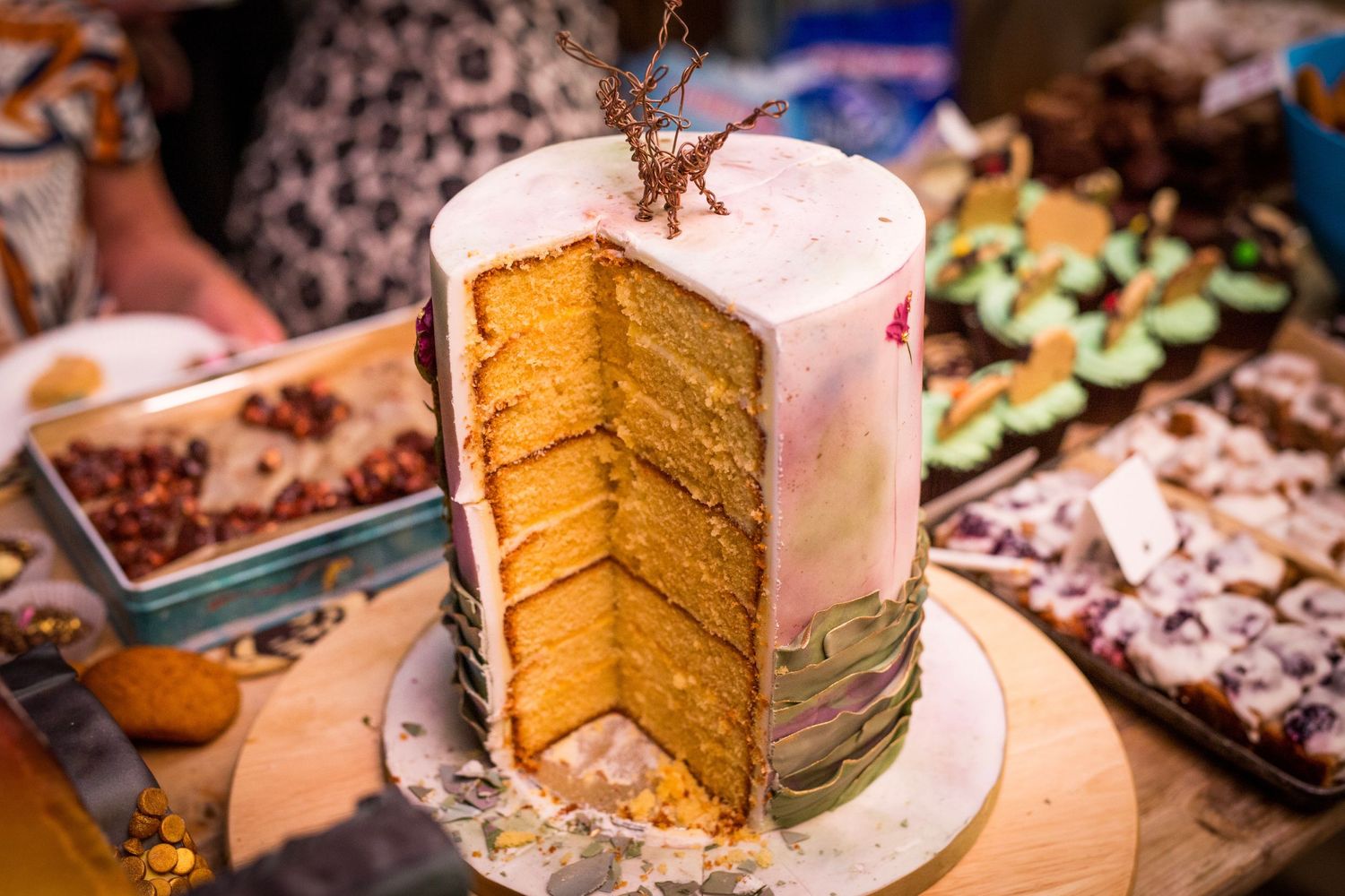 Elegant layered wedding cake with white frosting and rustic decorative elements.