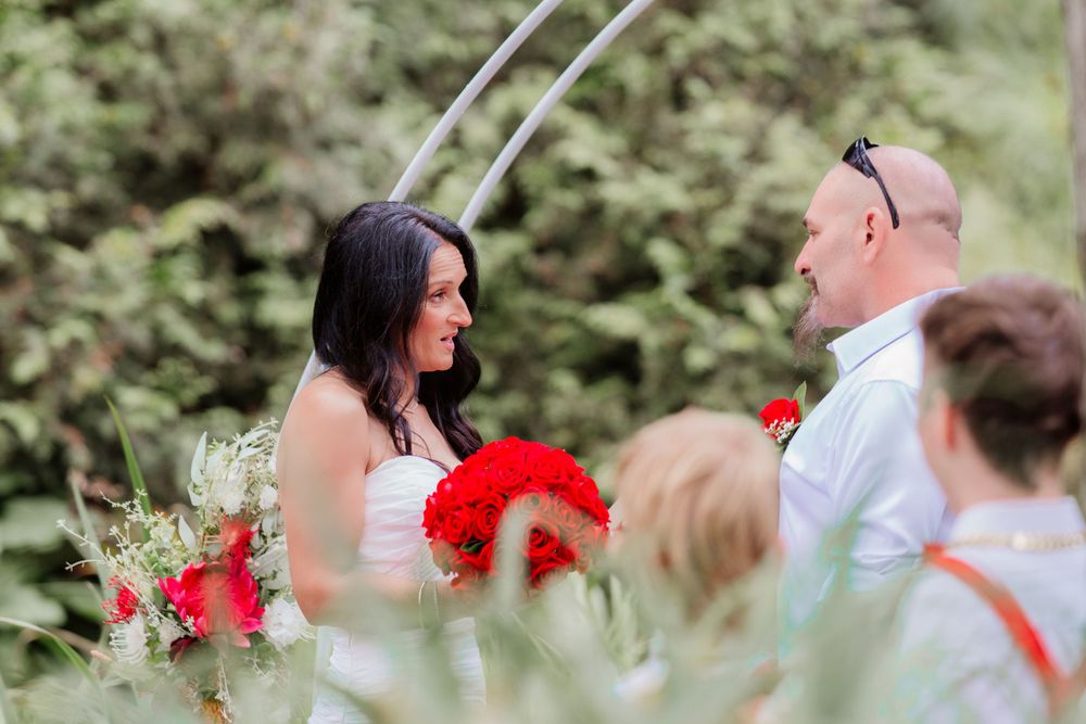 Garden photoshoot scene with attendees wearing coordinated white and red outfits.