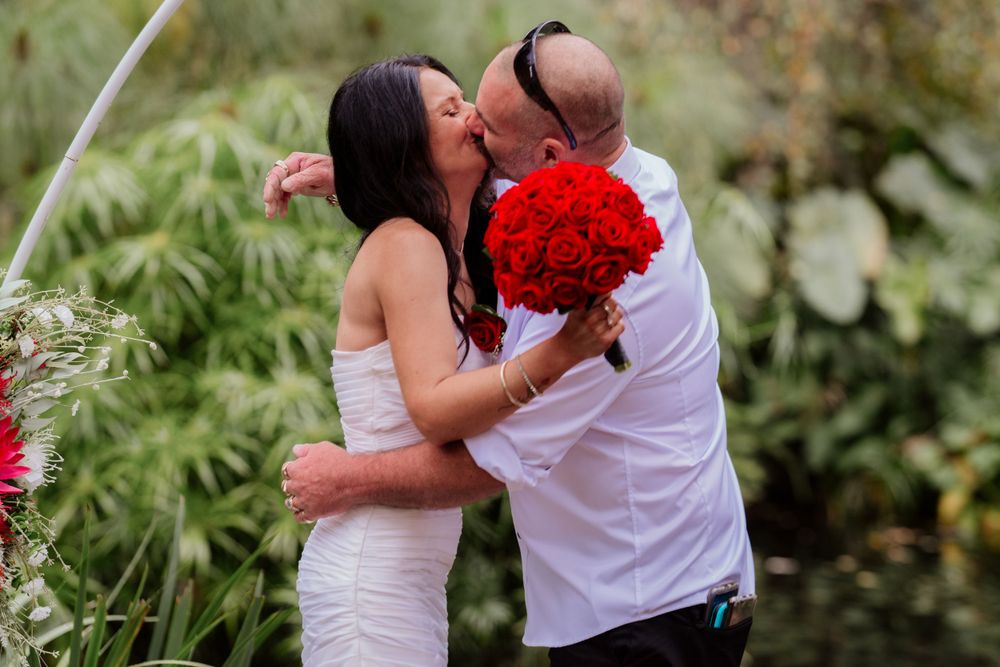 Romantic garden scene with couple sharing intimate moment among greenery.