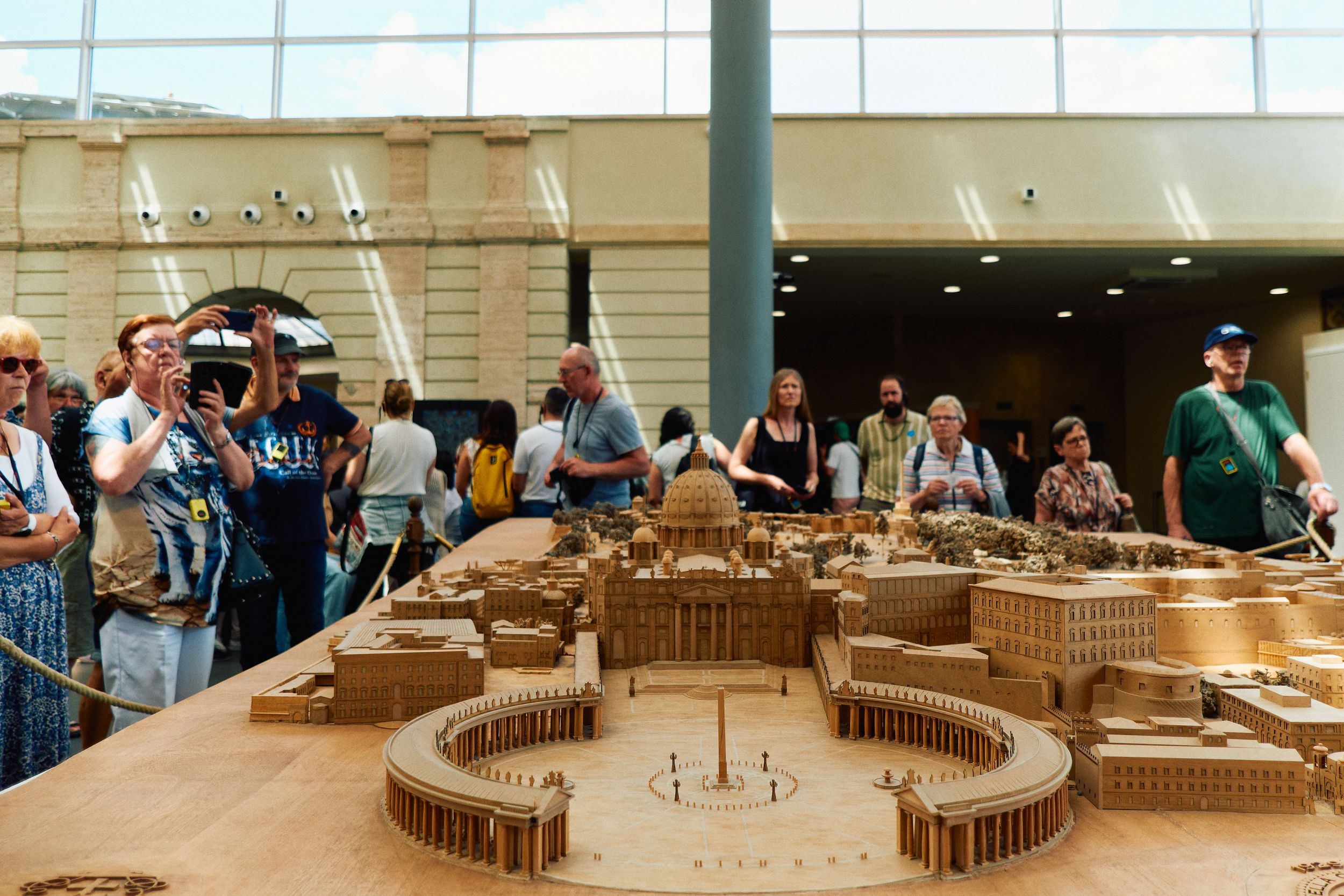 Scale model of the Colosseum surrounded by tourists viewing the architectural display.