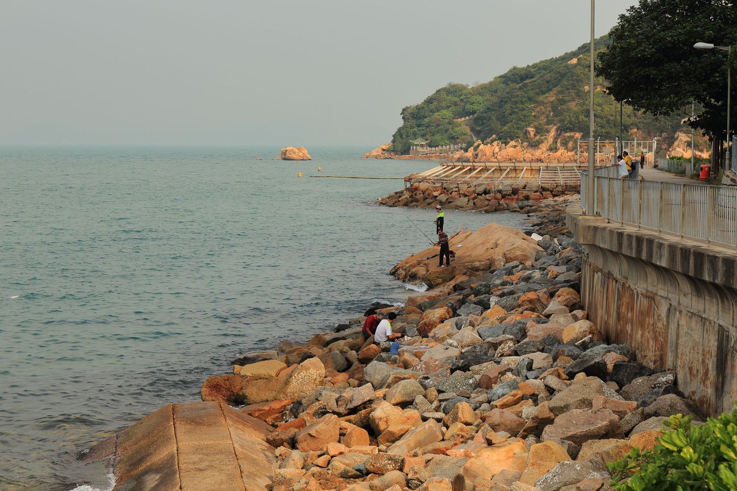 Rocky shoreline with fishing spot along Hong Kong's coast at sunset.