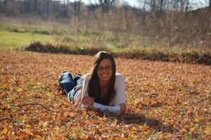 Woman lying in autumn leaves during outdoor photo session.