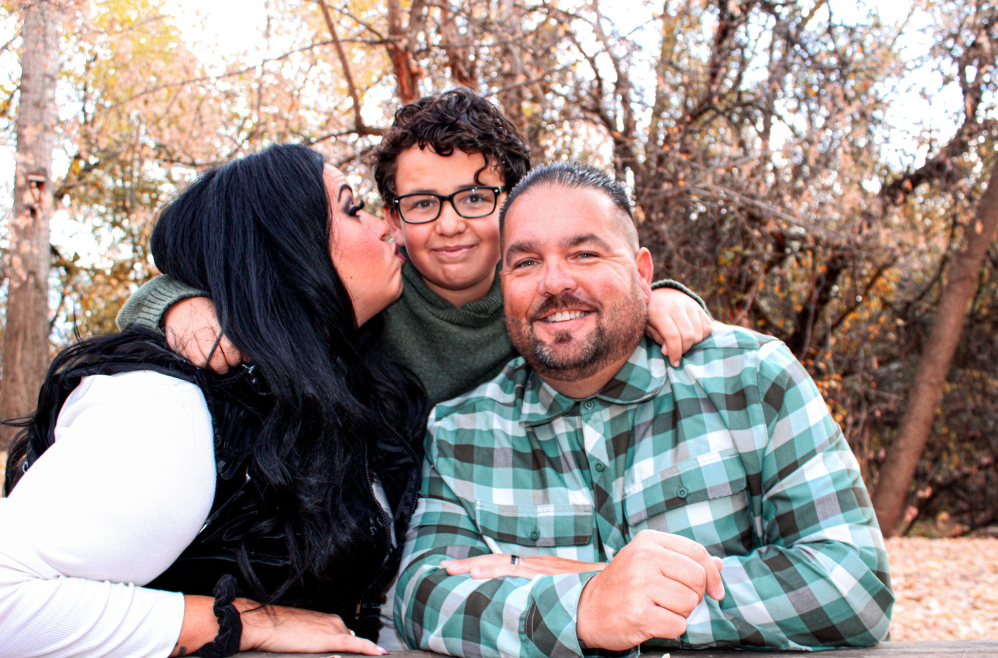 A family shares a warm moment together in an autumn setting.