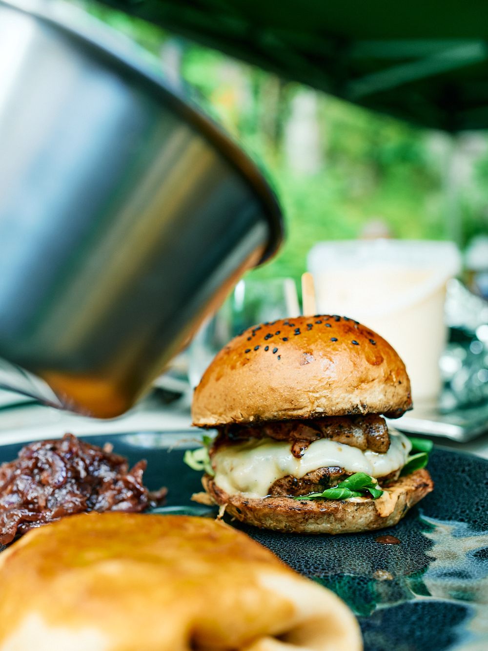Juicy cheeseburger with melted cheese and sesame bun photographed in natural lighting.