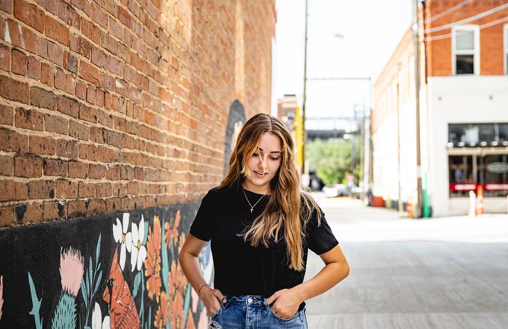senior girl walking down alley way
