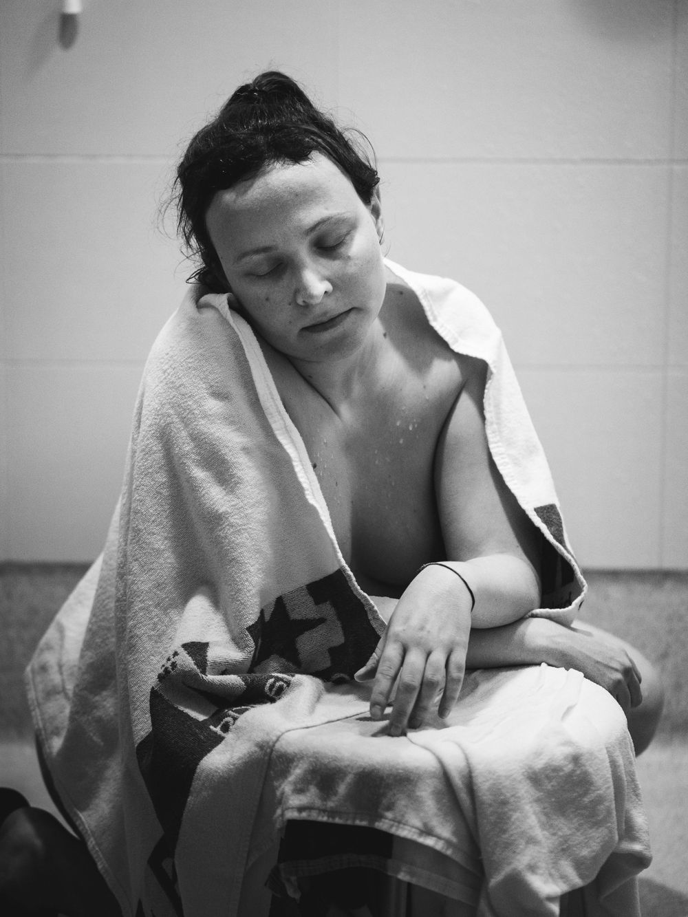 Black and white images show mother nursing newborn in hospital.