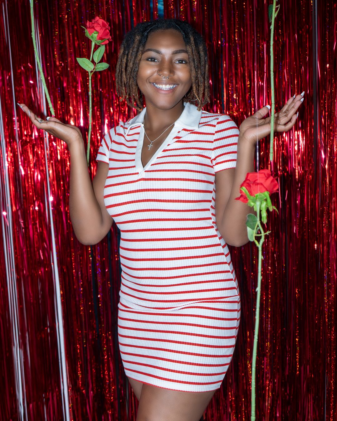 A striped dress against a red metallic curtain backdrop with roses.