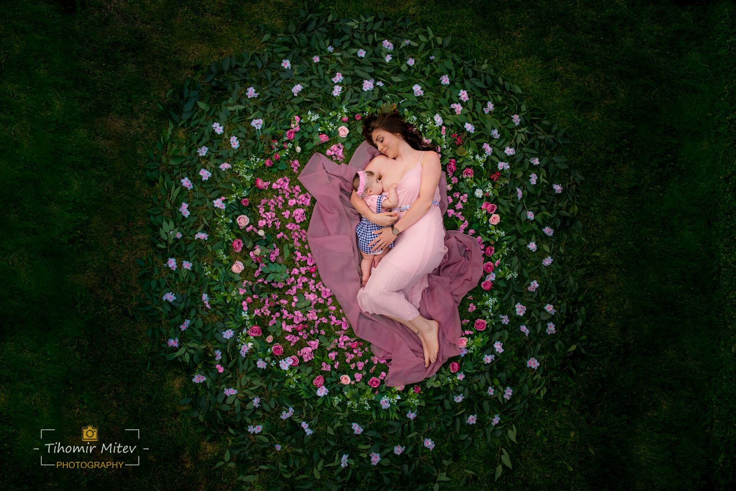 Арт фотография на майка, която кърми своето бебе в кръг от цветя