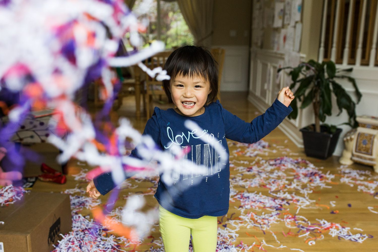 JoJo playing with confetti paper in the living room