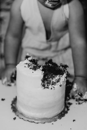 Close-up of a smashed white cake with crumbs scattered across the surface.