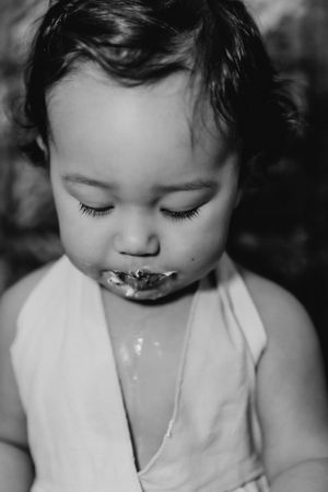 Black and white photo of messy cake smashing with frosting everywhere.