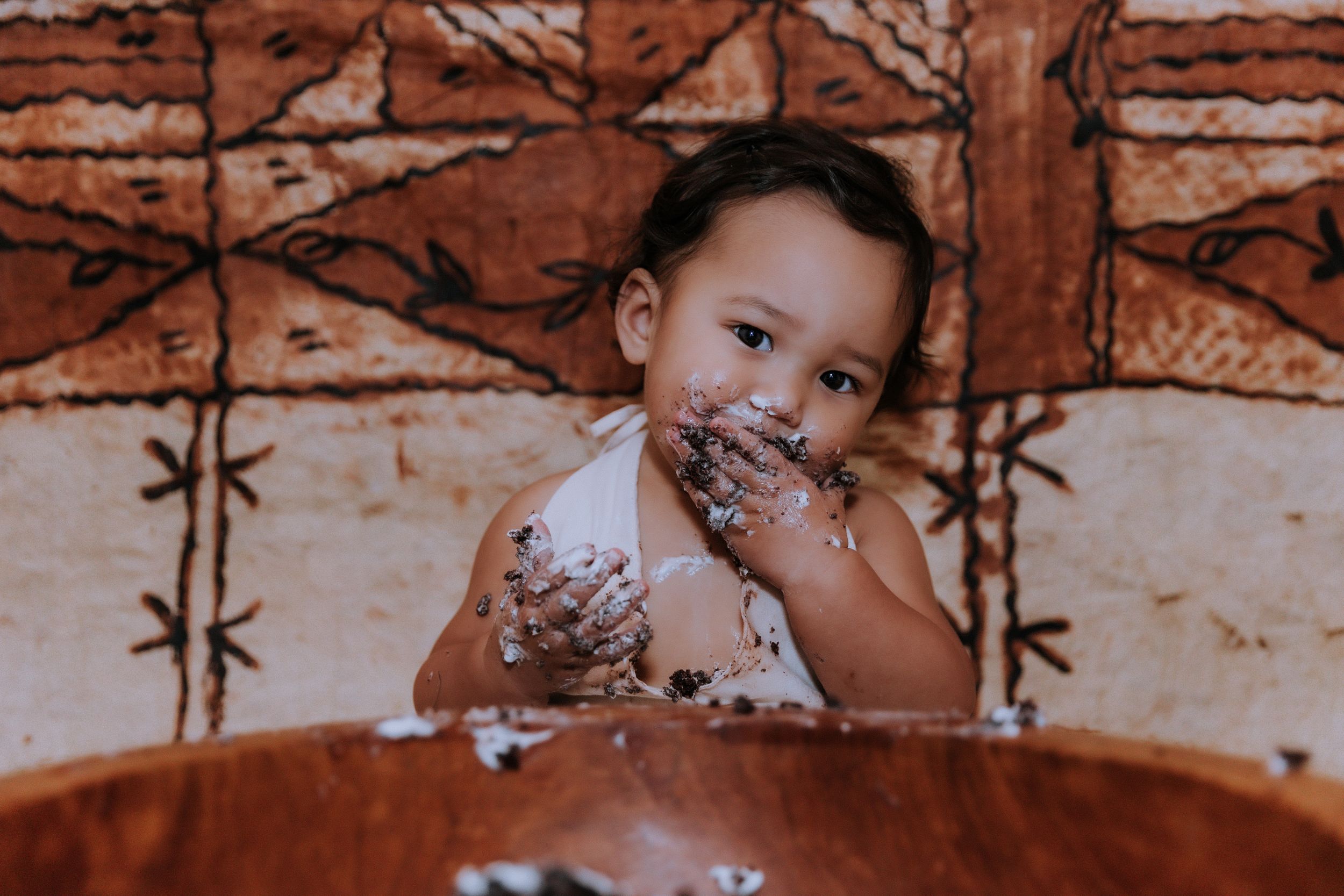 A series of sepia-toned photos showing a child enjoying cake.