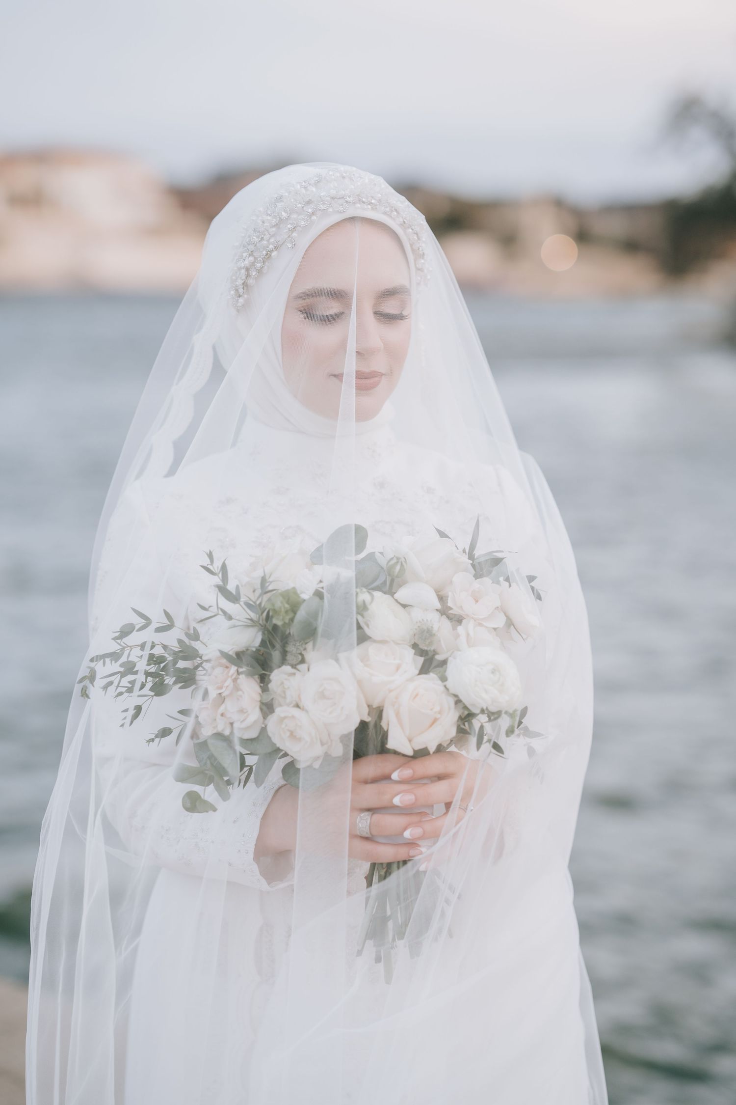 Dallas bride with a face covered by her veil and carrying a bouquet of flowers.