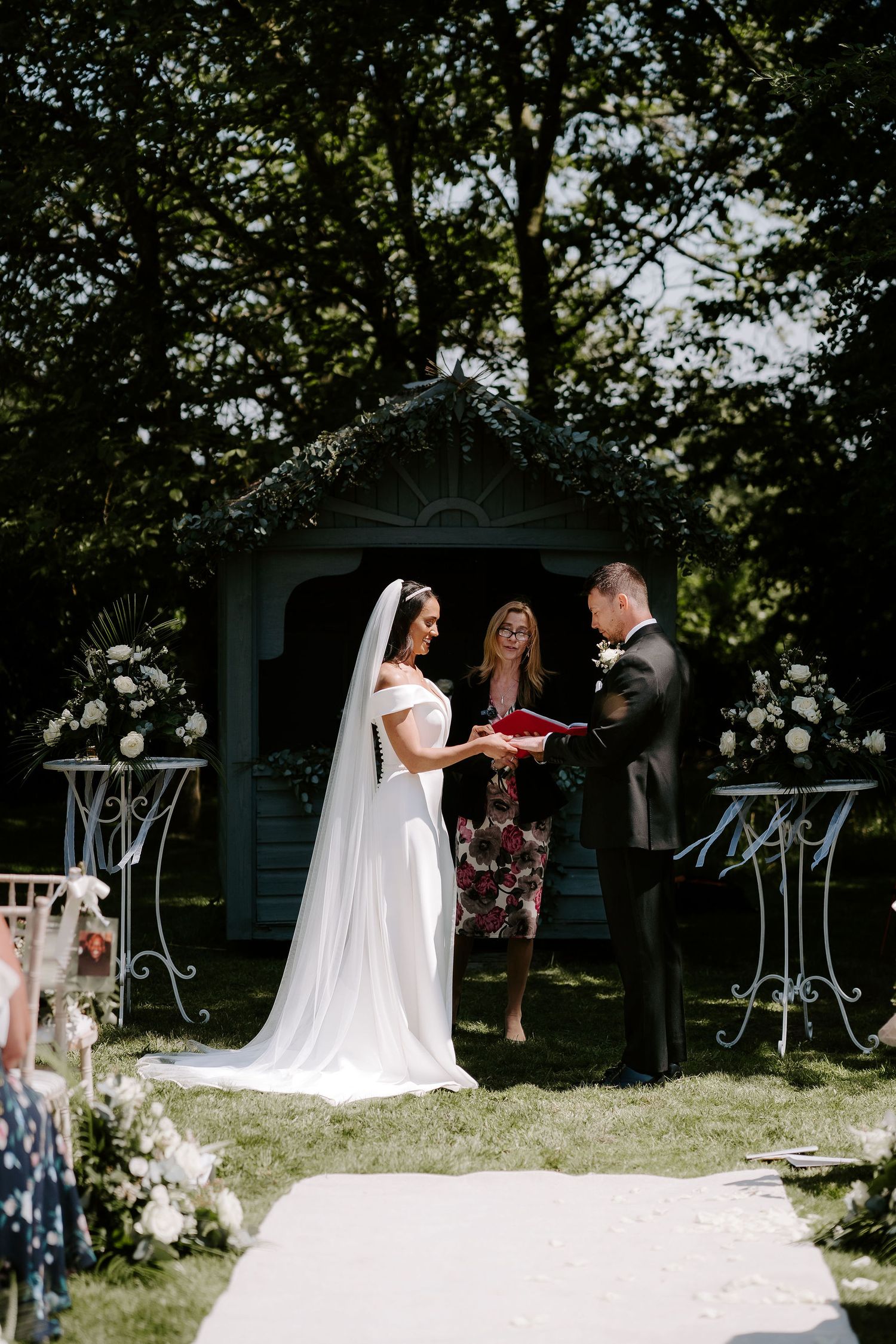 bride-and-groom-exchanging-wedding-rings-stockton-house-outdoor-wedding-ceremony