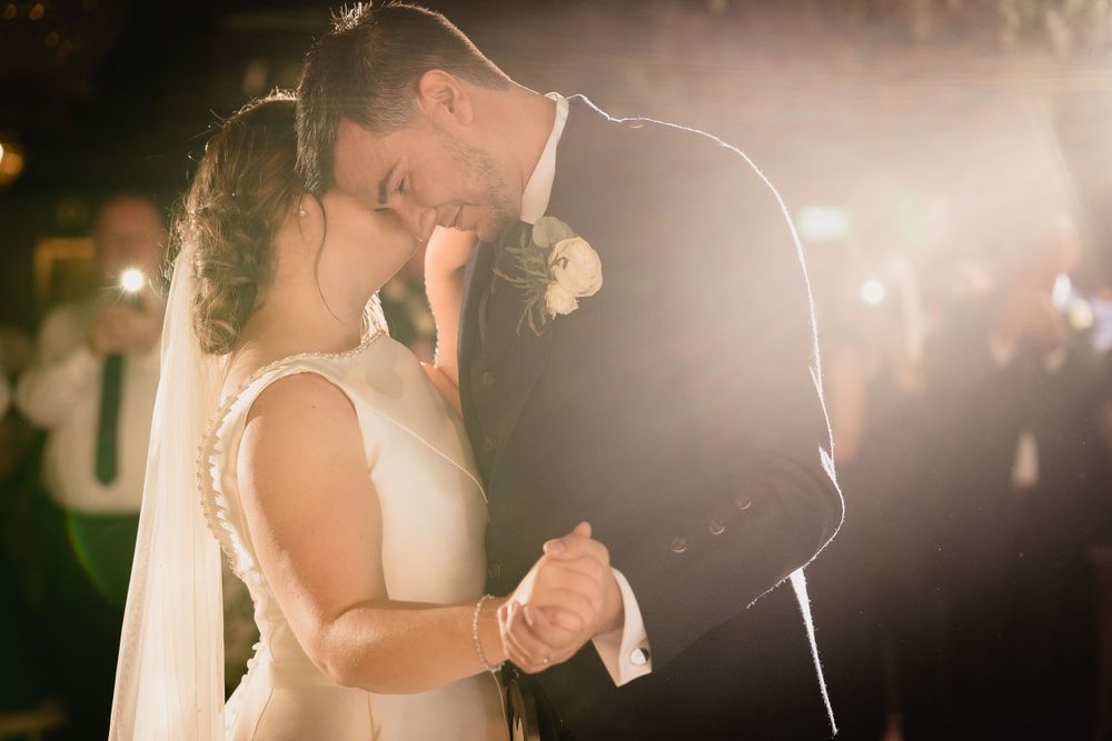 Romantic first dance silhouetted against soft evening lighting.