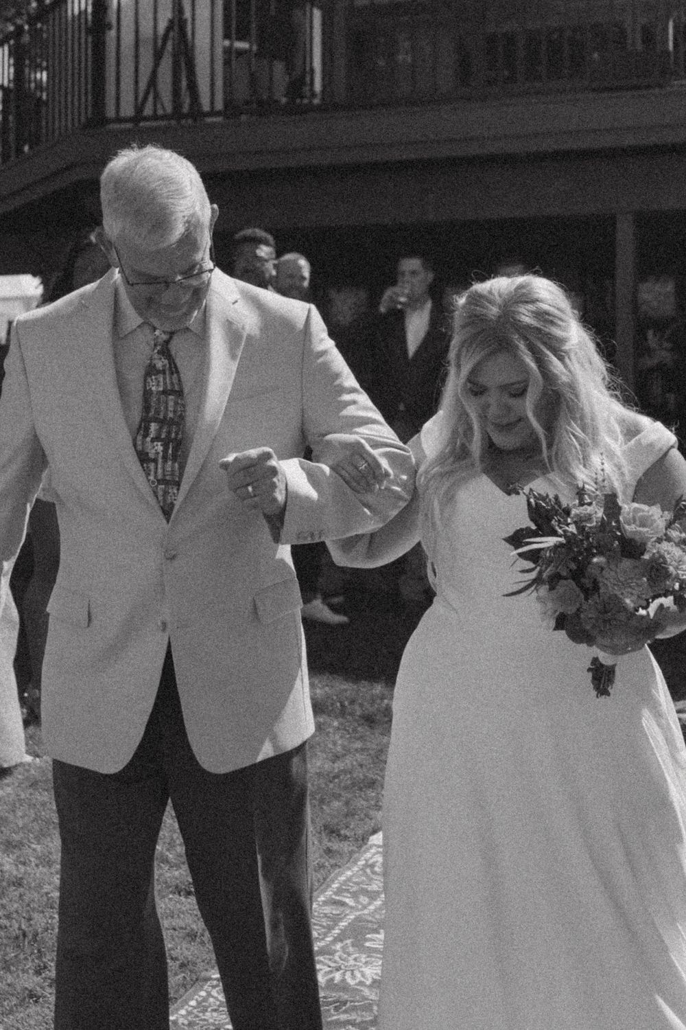 A formal outdoor wedding moment captured in black and white.