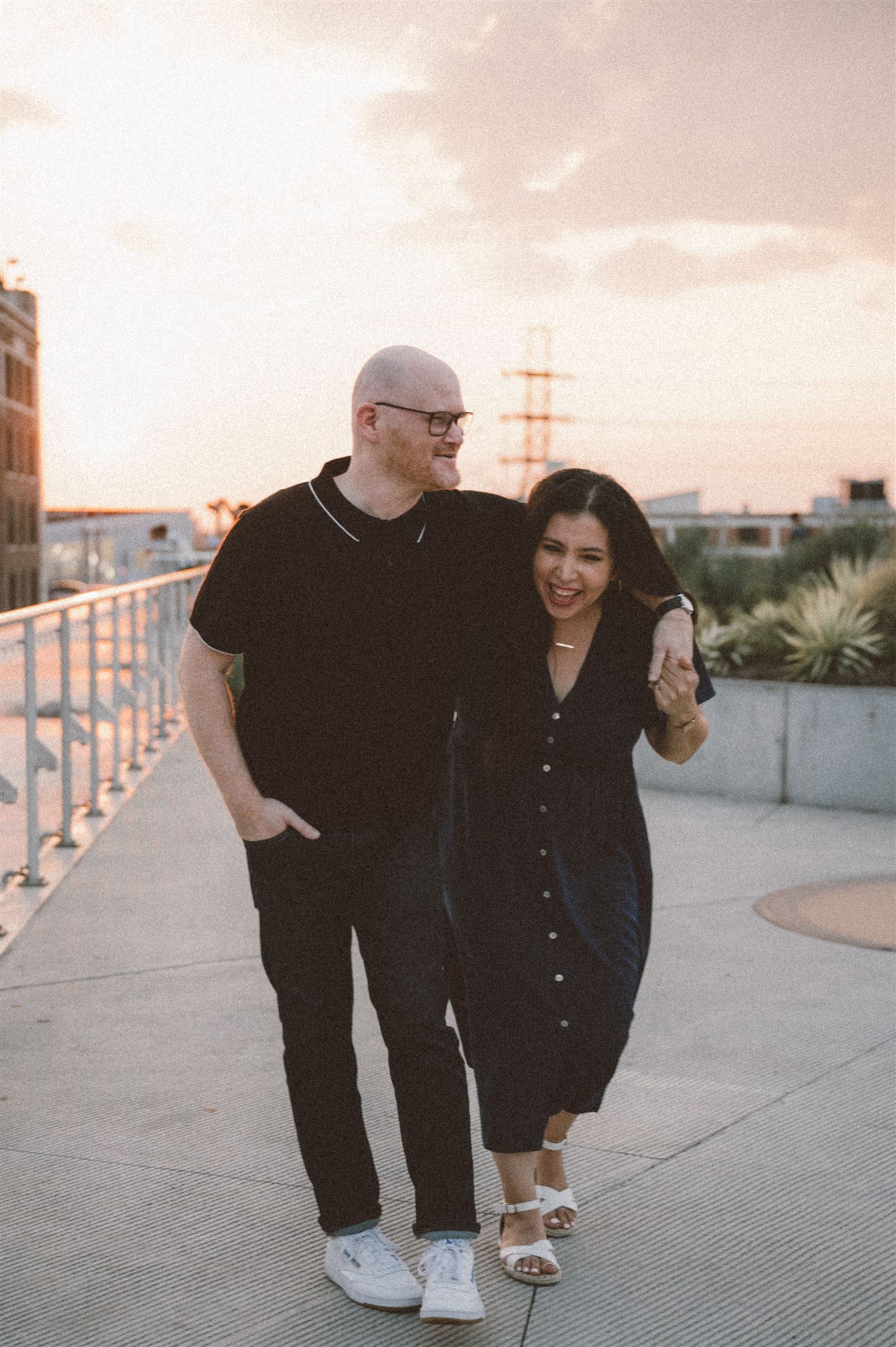 A couple enjoying a romantic sunset moment together on an urban rooftop terrace.