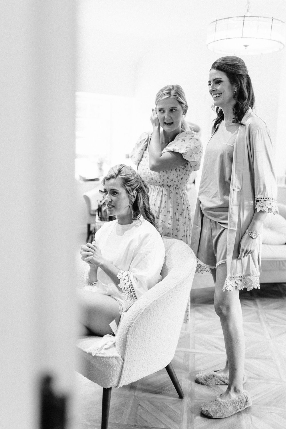 A candid moment during wedding preparations in a bright white room.