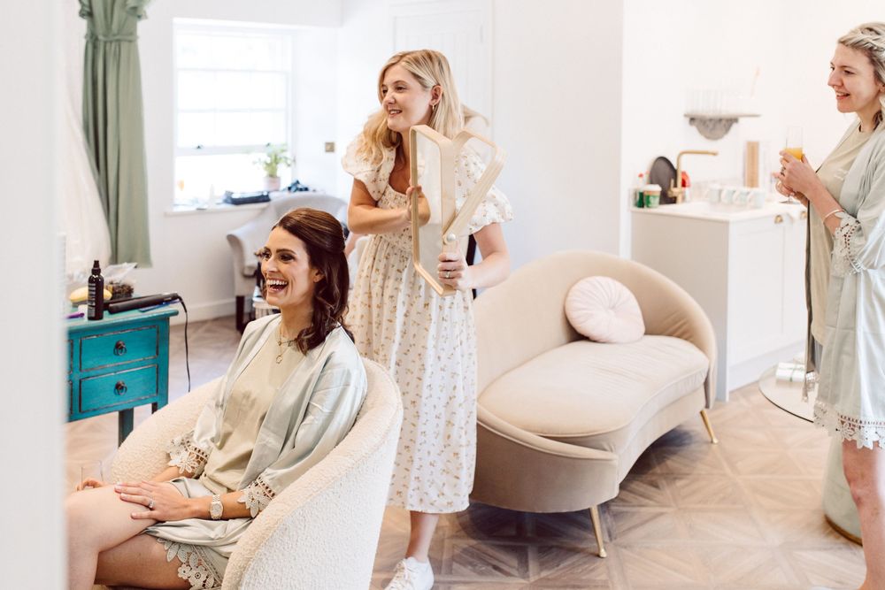 A bright dressing room with vintage furniture and floral wallpaper for wedding preparations.