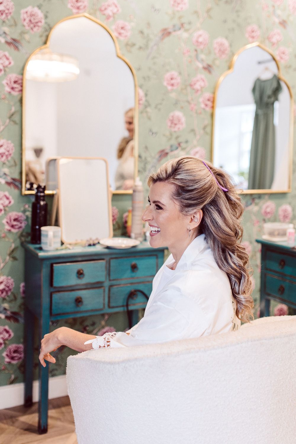 A bridal suite with vintage turquoise furniture and floral wallpaper.