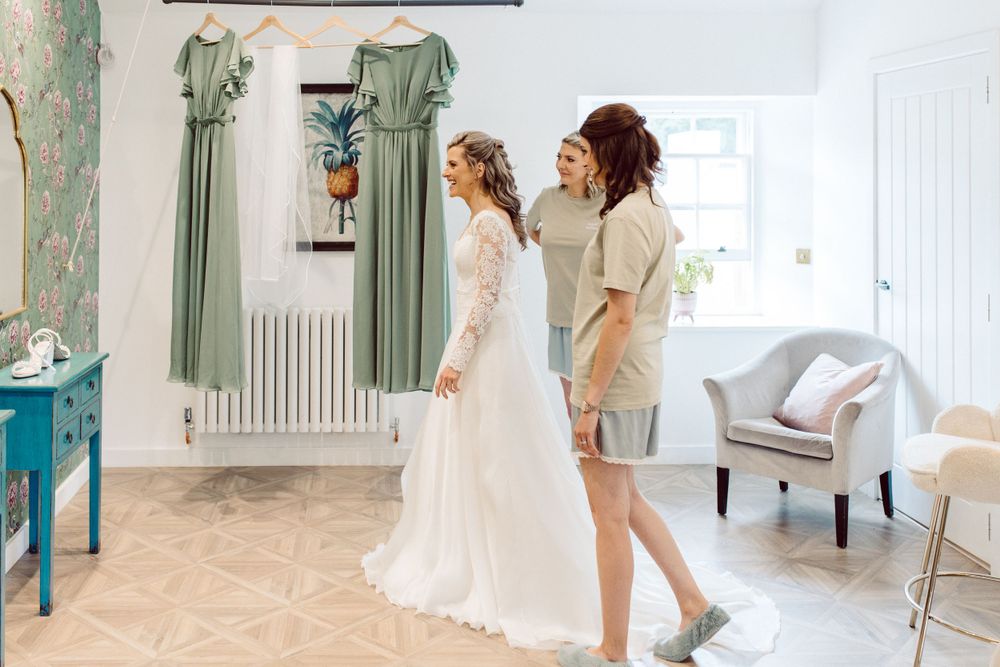 A bridal preparation room with elegant decor and multiple wedding gowns on display.