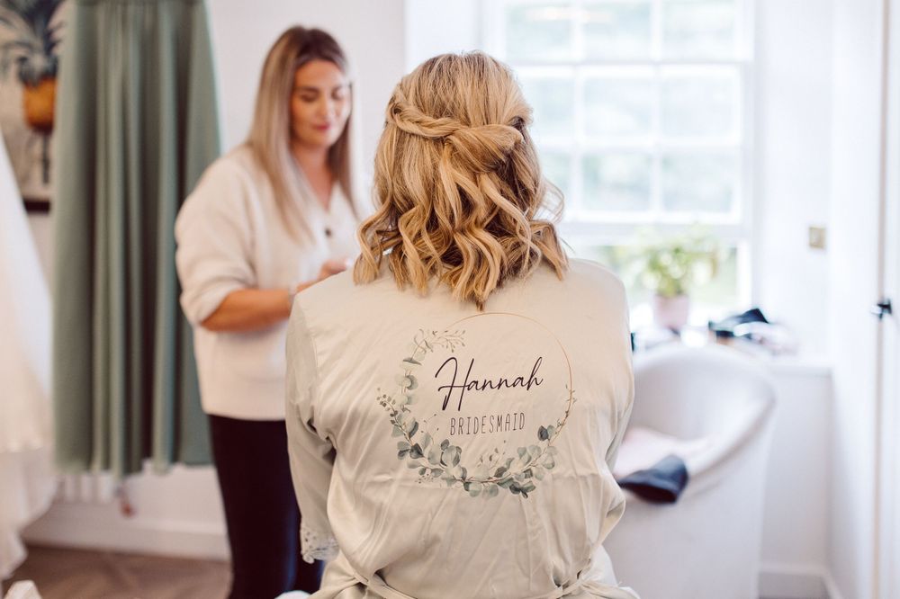 A bright dressing room with white robes and wedding day preparations.