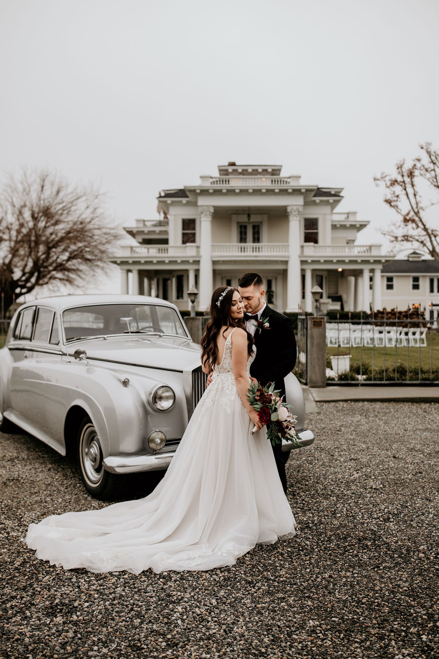 Bride and Groom stand beside vintage Rolls Royce outside of The Moore Mansion in Pasco, WA.