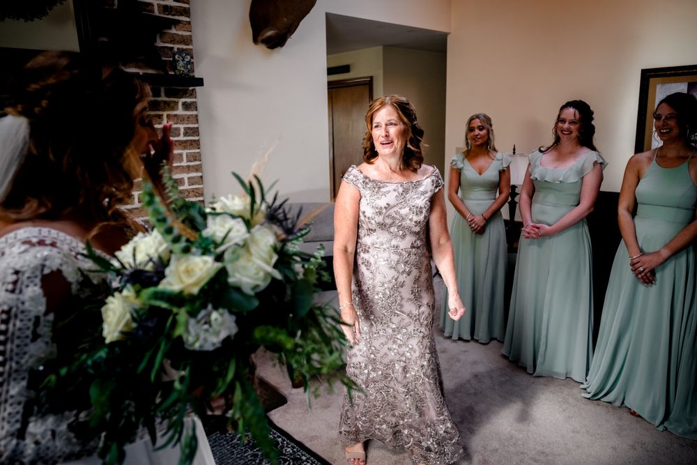 Wedding party in mint dresses and silver sequins gathered in a brick-walled room.
